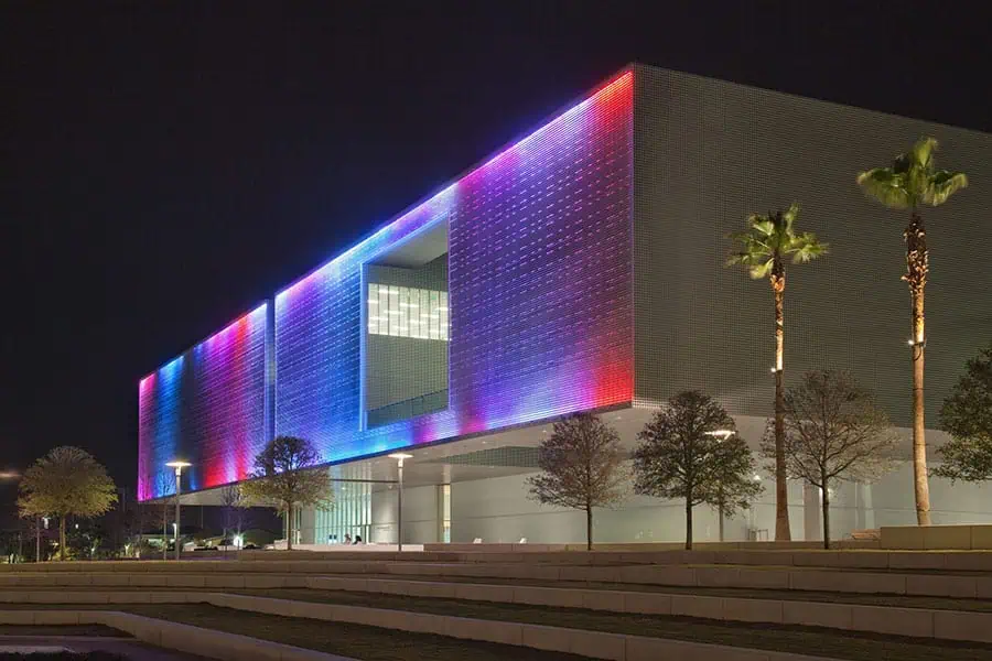 Tampa Museum of Art - A modern rectangular building at night with vibrant multi-colored LED lighting
