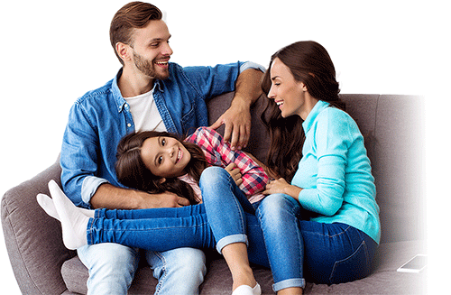 Happy family sitting on a couch, smiling and enjoying time together.